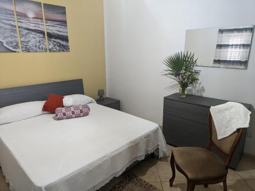 1 dormitorio con 1 cama y 1 silla en Villa Nel Verde - Bonsignore, en Tricase