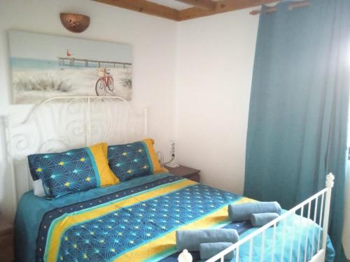 Schlafzimmer mit einem Bett mit blauen und gelben Kissen in der Unterkunft ON THE BEACH in Costa Teguise