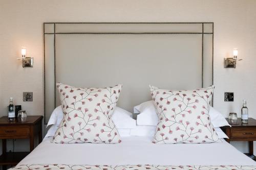 a bed with red and white pillows and two lamps at The Grand Hotel in Eastbourne
