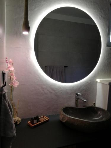 a bathroom with a sink and a round mirror at Relax tiny villas 40 meters of the beach in Korčula