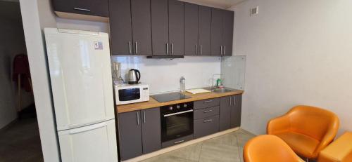 a kitchen with brown cabinets and a white refrigerator at Family apartment 2 rooms in Kharkiv