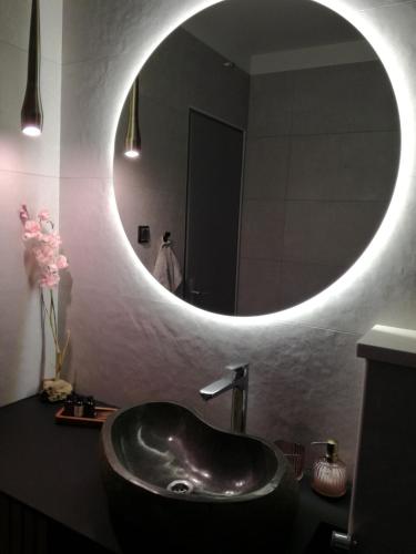 a bathroom with a sink and a round mirror at Relax tiny villas 40 meters of the beach in Korčula
