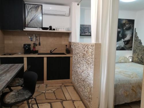 a kitchen with a desk and a bed in a room at Relax tiny villas 40 meters of the beach in Korčula