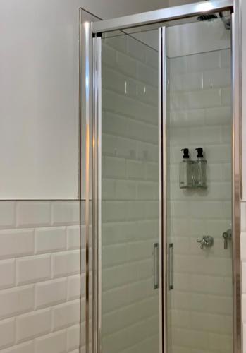 a shower with a glass door in a bathroom at HABITARE Lecce & Salento in Lecce