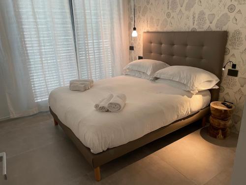 a bedroom with a large bed with towels on it at La Torre del Porto in Riccione
