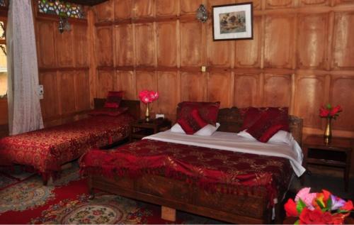 um quarto com uma cama e uma cadeira num quarto em Alif Laila Group of Houseboats, Srinagar em Srinagar