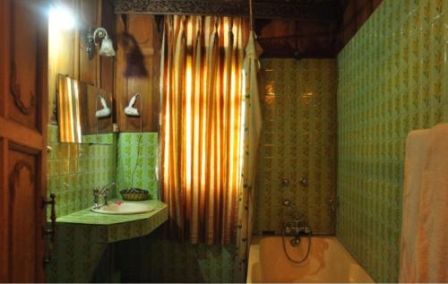 a bathroom with a shower and a sink and a tub at Alif Laila Group of Houseboats, Srinagar in Srinagar