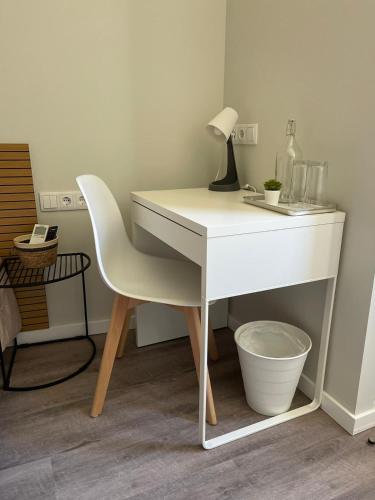a white desk with a chair and a lamp at Centro da Vila in Ponte de Lima