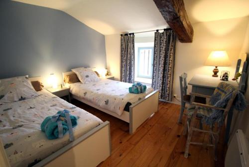 um quarto com 2 camas, uma mesa e uma secretária em Les moissonneurs em Champagnac-la-Rivière