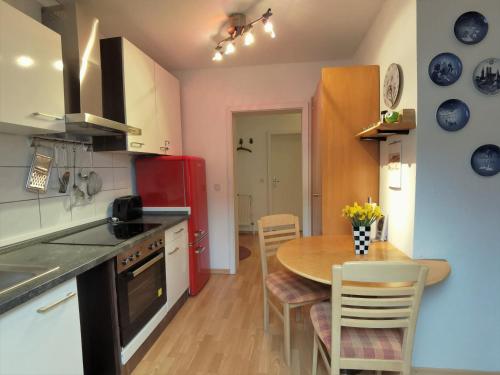 eine Küche mit einem Tisch und einem roten Kühlschrank in der Unterkunft Ferienwohnung Kobs in Ausacker