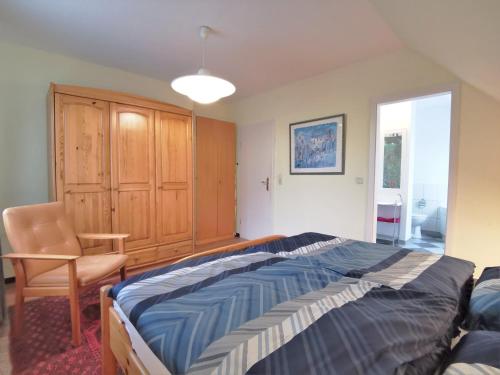 ein Schlafzimmer mit einem Bett und einem Stuhl darin in der Unterkunft Ferienwohnung Kobs in Ausacker