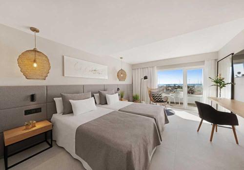 a bedroom with a large bed and a dining room at Hotel Almudaina in Palma de Mallorca
