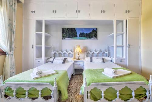 Un dormitorio con dos camas con sábanas verdes. en Villa Puchero - PlusHolidays, en Calpe