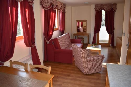 a living room with red curtains and a red couch at Aparthotel Snjezna Kraljica in Zagreb