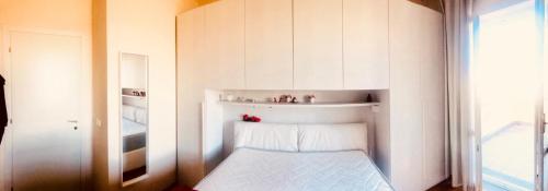 a small white room with a bed and a window at Villetta rosso Rubino in Vignale Monferrato