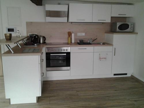 a kitchen with white cabinets and a stove top oven at Malerwinkel & Tuchereck in Michelstadt