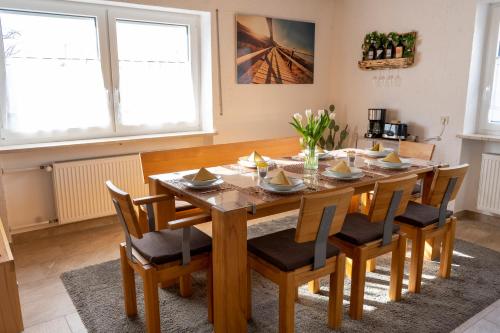 a dining room with a wooden table and chairs at Ferienwohnung Hertreiter in Dingolfing 110qm in Dingolfing