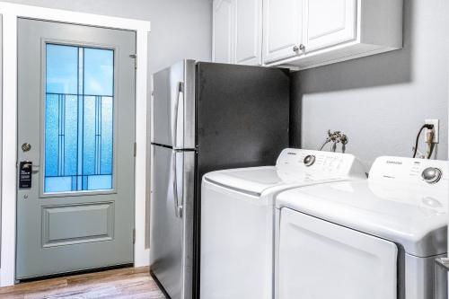 eine Küche mit einem Kühlschrank, einer Waschmaschine und einem Trockner in der Unterkunft Fun & Games in Union
