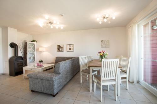 - un salon avec un canapé, une table et des chaises dans l'établissement Ferienwohnung Strandnest Sierksdorf, à Sierksdorf