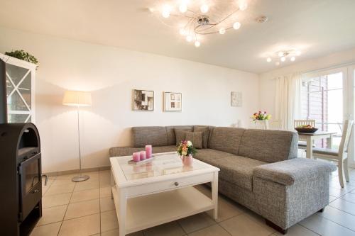 - un salon avec un canapé et une table dans l'établissement Ferienwohnung Strandnest Sierksdorf, à Sierksdorf