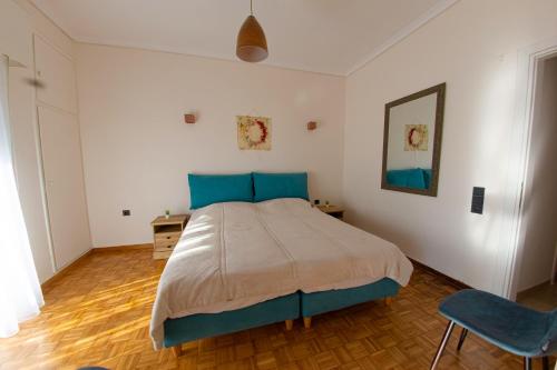a bedroom with a large bed with blue pillows at Esperidon Luxury Apartment Glyfada in Athens