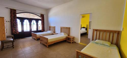 a room with two beds and a large window at Rayhana Guest House in Marsa Alam City