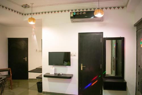 a room with two doors and a tv on the wall at Hotel Banjara Heritage in Udaipur