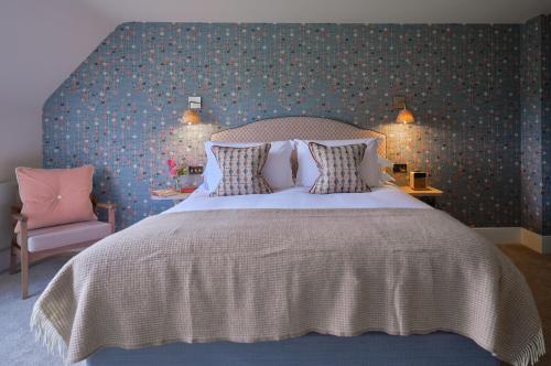 a bedroom with a large bed and a chair at Elsker in Broadway