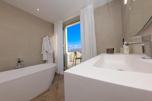 a bathroom with a large white tub and a window at Maria Die in Calvi