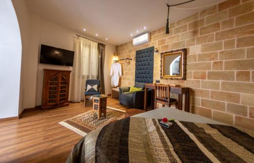 1 dormitorio con pared de ladrillo y 1 cama en una habitación en Utopia Luxury Suites - Old Town en Rodas