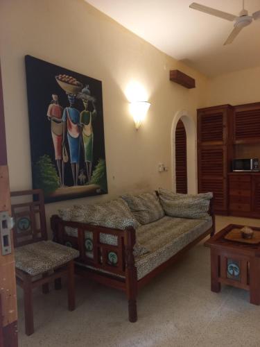 a living room with a couch and a painting on the wall at Azuri Homes Malindi, Stylish 1 bedroom beach front villa in Malindi