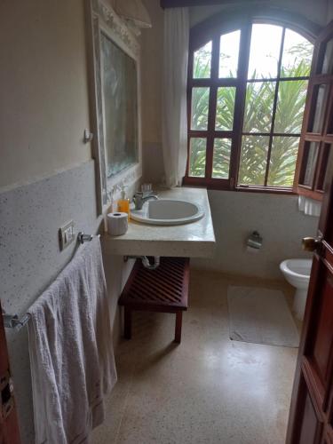 a bathroom with a sink and a toilet and a window at Azuri Homes Malindi, Stylish 1 bedroom beach front villa in Malindi