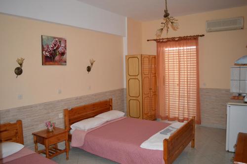 - une chambre avec 2 lits et une fenêtre dans l'établissement VIRGINIA STUDIOS, à Anaxos