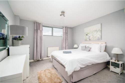 um quarto branco com uma cama grande e uma janela em Stylish Apartment Close to London Bridge em Londres