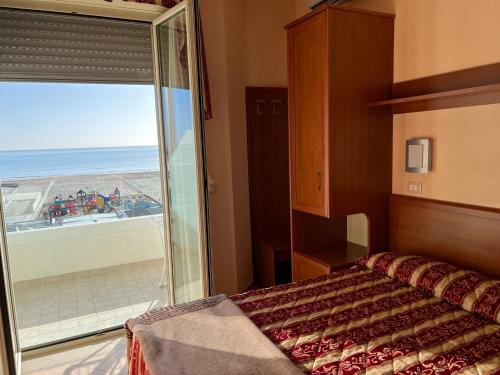 切爾維亞的住宿－布里斯托酒店，一间卧室配有一张床,享有海滩美景