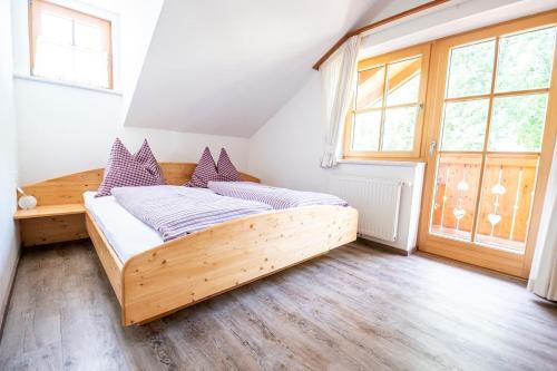 a bedroom with a wooden bed and a large window at Ferienhaus Ennsling in Haus im Ennstal