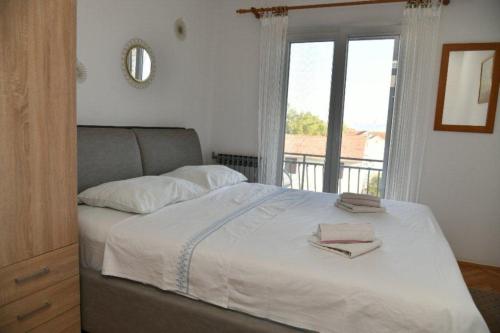 una camera da letto con un grande letto e una finestra di Apartments Val - 300 m to the beach a Supetar (San Pietro di Brazza)