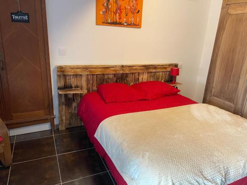 een slaapkamer met een bed met rode kussens bij Propriétaire privé in Carcassonne