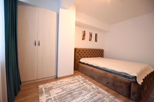 um pequeno quarto com uma cama e um closet em Blue Tower Apartments em Suceava