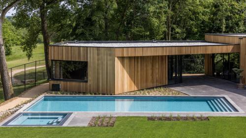 une maison avec une piscine dans une cour dans l'établissement Dormio Resort Maastricht Castellum Apartments, à Maastricht