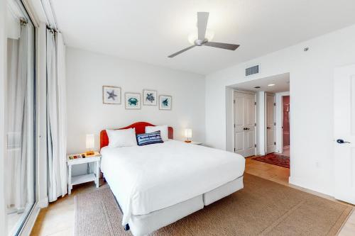 1 dormitorio blanco con 1 cama y ventilador de techo en Portofino Island Resort and Spa Tower One 1108, en Pensacola Beach
