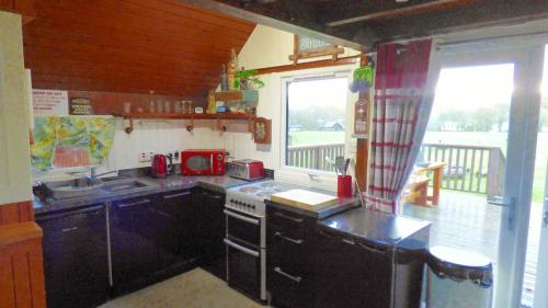 a kitchen with a stove and a sink at Iona Cabin in Taynuilt