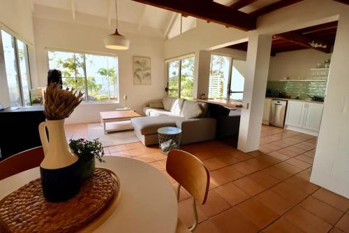 a living room with a table and a couch and a kitchen at Maleny-Montville Cottages in Balmoral Ridge