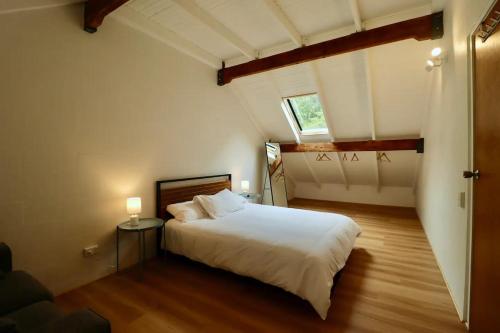 a bedroom with a large white bed and a window at Maleny-Montville Cottages in Balmoral Ridge