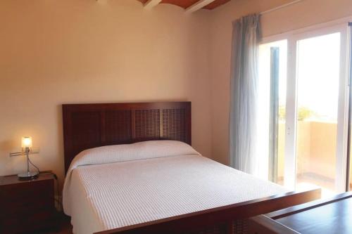um quarto com uma cama e uma grande janela em Casa con impresionantes vistas al mar em Tossa de Mar