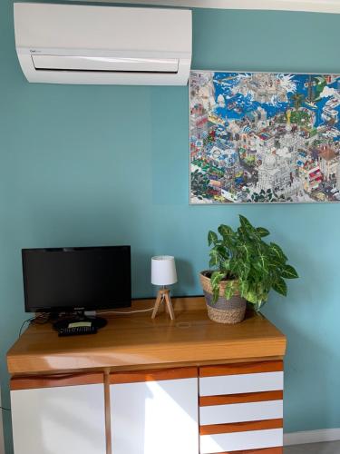 biurko z telewizorem i obrazem na ścianie w obiekcie Le Studio Sausset w mieście Sausset-les-Pins