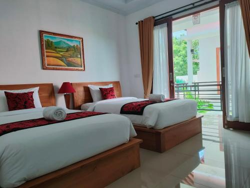 1 dormitorio con 2 camas y balcón en Lo Sari Bungalow, en Batununggul