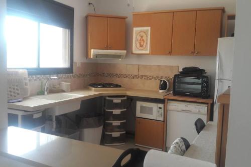 a small kitchen with a sink and a microwave at nadera place in Shefar‘am