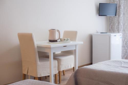 um quarto com uma mesa e duas cadeiras e uma cama em Baltosios Bures em Kaunas