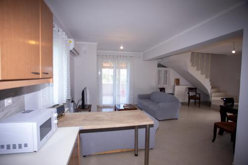 a kitchen and living room with a couch and a microwave at Casa di Castellano in Corfu